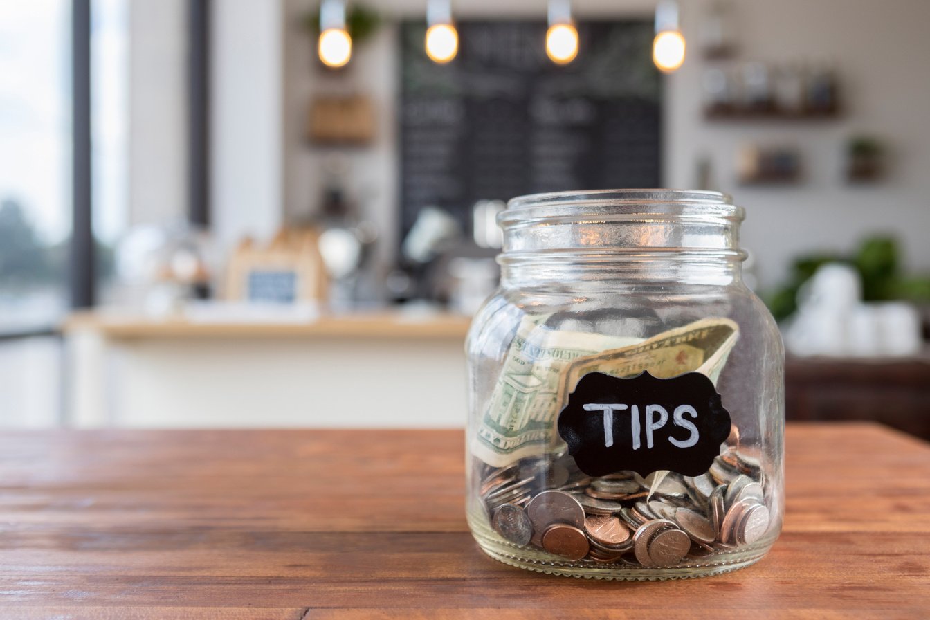 ""Tips"" jar on coffee shop table