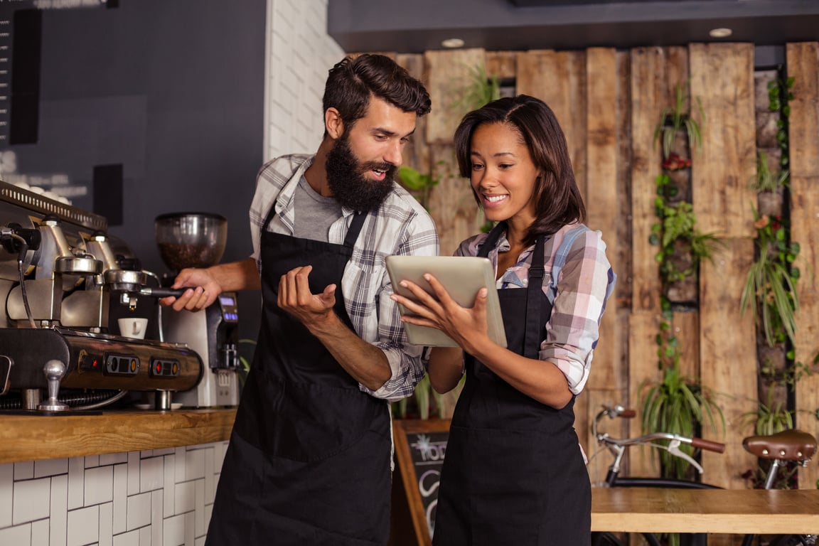 Waiter and waitresses using laptop while working